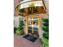Elegant building entrance featuring gold trim, brick walkway, and well-maintained landscaping at 77 Peachtree Ne Pl # 211, Atlanta, GA 30309