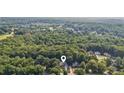 Aerial view of a beautiful home nestled in a lush, green neighborhood with mature trees at 5195 Overbend Trl, Suwanee, GA 30024