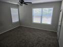 Well-lit bedroom with neutral walls, plush carpeting, and windows with blinds for privacy and comfort at 3120 Chattahoochee Rd, Cumming, GA 30041