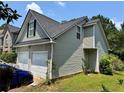 Side view of a two-car garage with vinyl siding and a well-maintained yard, providing ample parking space at 3140 Ridge Hill Pkwy, Douglasville, GA 30135