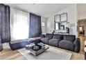 Stylish living room featuring a large sofa, light wood flooring, and modern decor at 3915 Basil Sw Way, Atlanta, GA 30331