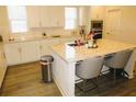 Bright kitchen featuring white cabinets, granite countertops, stainless steel appliances, and an island with seating at 3411 Swallowtail Ter, Duluth, GA 30096
