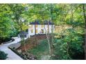 Stunning exterior view of a white two-story home nestled among lush greenery and a winding driveway at 6090 River Chase Cir, Atlanta, GA 30328