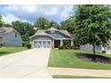 Inviting curb appeal with a well-maintained lawn, charming shrubbery, and a classic two-car garage at 5714 Pickens Garden Ln, Powder Springs, GA 30127