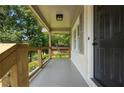 Inviting front porch showcasing natural wood railings and views of the surrounding greenery at 1409 Georgia Ave, East Point, GA 30344