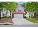 Charming two-story home featuring a two-car garage, red roof, and manicured front yard at 231 Silver Fox Trl, Dallas, GA 30157