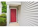 Inviting entrance featuring a bright red front door, gray siding, and fresh landscaping at 231 Silver Fox Trl, Dallas, GA 30157