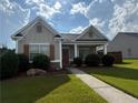 Inviting single-story home featuring a covered entryway and lush, green landscaping at 2979 Dungeness Dr, Douglasville, GA 30135