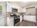 Well-lit kitchen boasts stainless steel appliances, granite countertops, and modern white cabinetry at 41 Elder St, Fairburn, GA 30213