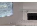 Close-up of a fireplace in the living room, highlighting the stone facade and natural light from the window at 733 Emerald Forest Cir, Lawrenceville, GA 30044
