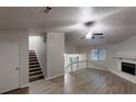 Spacious living room featuring hardwood floors, a fireplace, staircase, and a ceiling fan at 733 Emerald Forest Cir, Lawrenceville, GA 30044