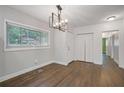 Inviting dining room features hardwood floors, closet space, a modern chandelier, and a large window at 2049 Rector Dr, Atlanta, GA 30311