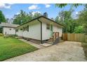 An inviting home featuring a well-kept lawn, a modern green door, an upgraded driveway, and wooden stairs at 2049 Rector Dr, Atlanta, GA 30311