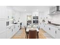 Modern white kitchen featuring updated appliances and cabinetry, and a eat-in table at 2658 Briarlake Ne Rd, Atlanta, GA 30345
