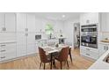 Bright eat-in kitchen with white cabinetry, stainless steel appliances, and stylish breakfast table at 2658 Briarlake Ne Rd, Atlanta, GA 30345