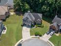 Aerial view of a two-story home with landscaped yard and large circular driveway on a sunny day at 3310 Mcclure Woods Ct, Duluth, GA 30096
