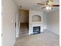 Cozy living room featuring a fireplace, ceiling fan, and staircase at 2320 Polaris Sw Way, Atlanta, GA 30331