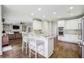 Open kitchen with white cabinets, granite countertops, island with seating and hardwood flooring at 730 Mount Oglethorpe Trl, Alpharetta, GA 30022