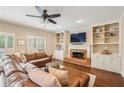 Spacious living room with a brick fireplace, built-in shelving, plantation shutters, and hardwood floors at 730 Mount Oglethorpe Trl, Alpharetta, GA 30022