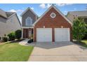 Charming two-story home with a red brick and gray siding, with a two-car garage and well-maintained lawn at 1265 Birchwood Ln, Roswell, GA 30076