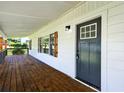 View of covered front porch featuring wood decking and shutters, and black front door at 5619 Beaver Sw Dr, Mableton, GA 30126