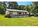 Inviting single-story home with a full front porch, metal roof and lush green lawn at 5619 Beaver Sw Dr, Mableton, GA 30126