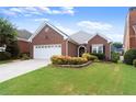 Attractive brick home featuring a green lawn, and manicured landscaping at 2323 Blackberry Ct, Snellville, GA 30078