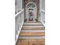 Inviting front entrance featuring a beautiful arched doorway with decorative wreath and stone accents at 241 Lost Lake Way, Villa Rica, GA 30180