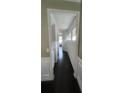 Hallway with dark wood floors, white trim, and plenty of natural light from nearby windows at 3750 Richmond Bnd, Lithonia, GA 30038