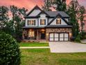 Charming two-story home boasts a stone facade, black-trimmed windows, and a cozy porch, blending elegance and comfort at 3640 Pollys Blf, Cumming, GA 30028