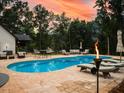 Inviting backyard oasis featuring a sparkling pool with comfortable lounge seating and lush landscaping for ultimate relaxation at 3640 Pollys Blf, Cumming, GA 30028