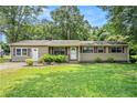 Single-story home featuring a well-kept lawn, complemented by mature trees and landscaping at 96 S Forty Pass S, Hiram, GA 30141