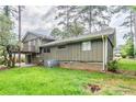 View of the home's backyard and exterior, with a small balcony above a concrete patio at 2110 Redbud Sw Ct, Marietta, GA 30008