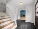 Inviting foyer features a staircase, dark tile flooring, and views into the adjacent living spaces at 2340 Castleridge Ct, Tucker, GA 30084
