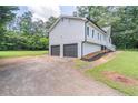Side view of the home with a two-car garage and a well-maintained lawn at 243 Hickory Way, Canton, GA 30115