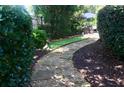 Stone pathway in a lush backyard, creating a serene and inviting outdoor space at 7825 Crownpoint Dr, Alpharetta, GA 30005