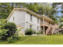 Two-story home with a front porch and stairs surrounded by greenery and trees at 537 Raven Springs Trl, Stone Mountain, GA 30087
