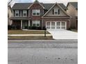 Charming two-story brick home with blue shutters, well-manicured lawn and two car garage at 3299 Arbor Oaks Dr, Snellville, GA 30039