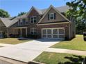 Beautiful two-story home featuring brick accents, attached garage, and a well-maintained front lawn at 3299 Arbor Oaks Dr, Snellville, GA 30039