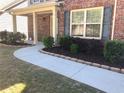 Inviting walkway leading to the front door, surrounded by neatly landscaped flower beds and lush green grass at 3299 Arbor Oaks Dr, Snellville, GA 30039