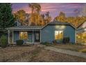 Charming blue single-story home with a cozy front porch and well-kept landscaping at dusk at 3918 S Creek Ct, Stone Mountain, GA 30083
