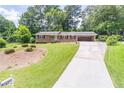 Well-maintained brick home featuring a long driveway and landscaped front yard at 4077 Phils Ct, Tucker, GA 30084