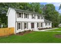 Beautiful two-story home with a well-maintained lawn, white exterior, and dark shutters at 4555 Holliston Rd, Dunwoody, GA 30360