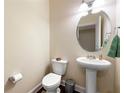 Neat half bathroom features pedestal sink, oval mirror, and neutral wall paint at 8295 Village Pl, Suwanee, GA 30024