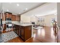 Open concept kitchen features granite island, stainless appliances, and hardwood floors at 8295 Village Pl, Suwanee, GA 30024