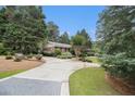 Spacious concrete driveway leading to a brick home surrounded by mature trees and manicured landscaping at 2221 Fairoaks Rd, Decatur, GA 30033