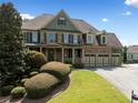 Beautiful front exterior with a manicured lawn and mature landscaping on a sunny day at 5585 Lavender Farms Rd, Powder Springs, GA 30127