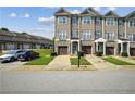 Inviting townhome features manicured lawns, attached garages, and a charming facade with stone and siding at 7710 Bucknell Terrace, Fairburn, GA 30213
