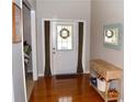 Warm entryway with hardwood floors, a console table, and a view of the glass-paneled front door at 2481 Southhaven Ln, Buford, GA 30519