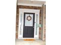 Stylish front door with sidelights, adorned with a wreath, and a charming welcome mat at 2481 Southhaven Ln, Buford, GA 30519